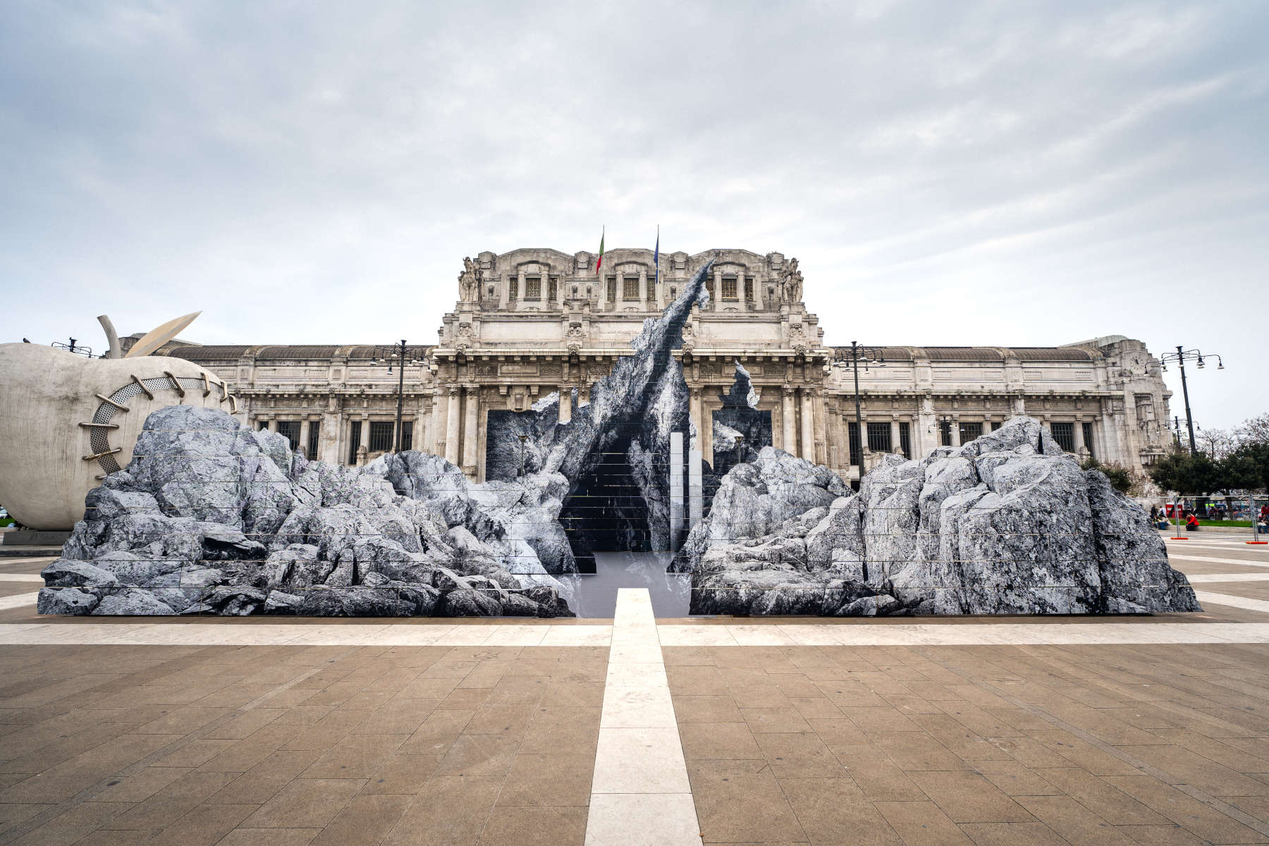 JR’s New Monumental Rock Installation ‘la nascita’ emerges in Front of Milan Central Station